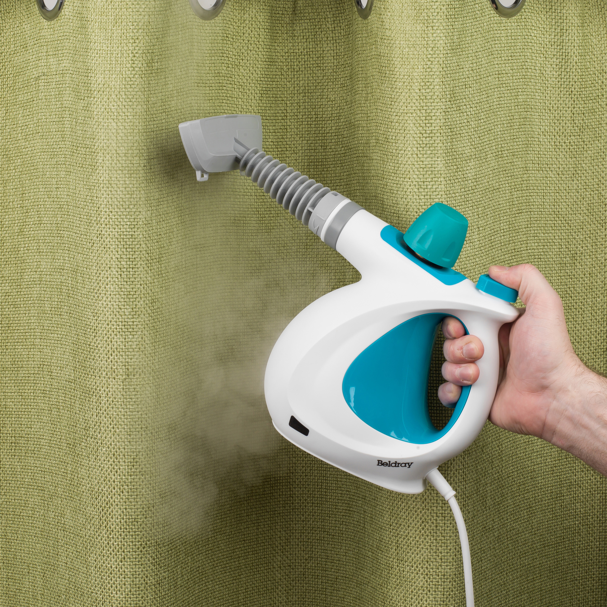 a handheld steam cleaner being used on curtains