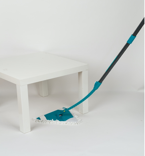 a flexible mop being used under a low table